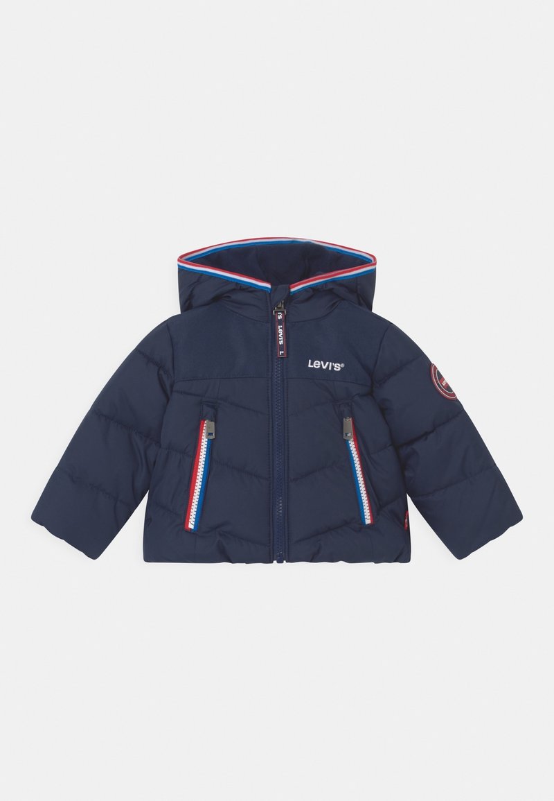 Giacca a soffietto blu navy con cappuccio, caratterizzata da un design trapuntato, doppia zip sul davanti, due tasche con zip e dettagli in rosso e bianco.
