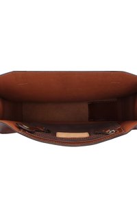 Borsa a mano in pelle marrone vuota con cuciture visibili e una piccola tasca interna attaccata vista dall'alto.