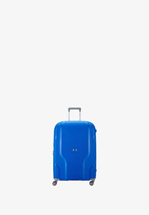 Valigia rigida blu con superficie texturizzata, dotata di manico telescopico, due ruote e forma arrotondata con linee di design sottili.
