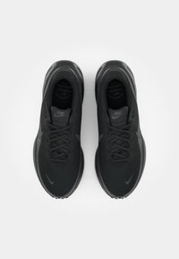 Svarta Nike löparskor med övre del av mesh, rund tå, snörning och dämpad sula; har en diskret swoosh-logotyp och texturerade detaljer.