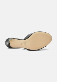 Base di scarpa in pelle nera con punta affusolata, caratterizzata da un upper liscio, una suola piatta e misura 37. La suola è beige con una leggera texture.