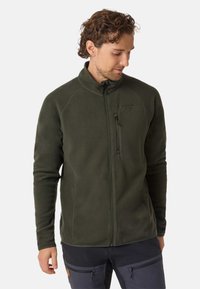 Giacca in pile verde con colletto alto, tasca sul petto con zip e maniche raglan, caratterizzata da una texture morbida e una vestibilità aderente.