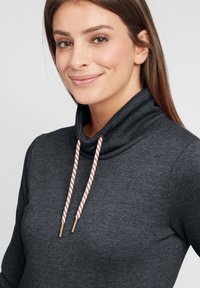 Mörkgrå hoodie med cowl-krage, utrustad med flätade dragsnören i vitt och koppar. Mjuk tygtextur och figurnära design.