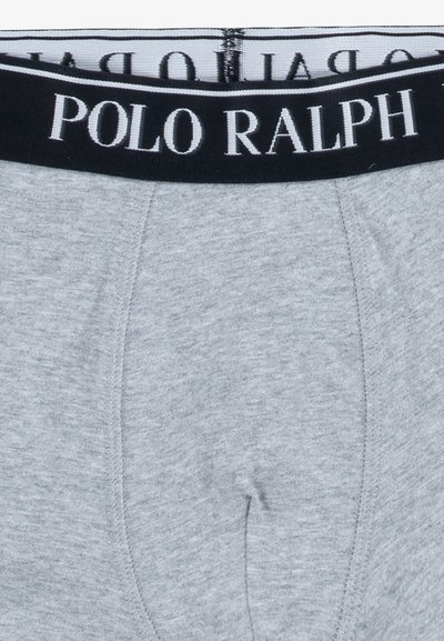 Sive bombažne boksarice z črnim elastičnim pasom, na katerem je v belem napisu "POLO RALPH". Gladka tekstura in standardna zasnova.