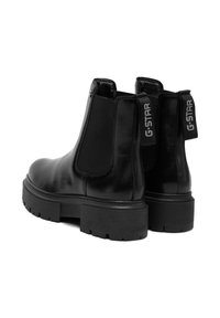 Czarne skórzane botki Chelsea z masywnymi gumowymi podeszwami, elastycznymi bocznymi panelami oraz oznaczeniami z logo "G-STAR" z tyłu.