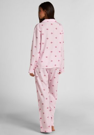 Rosa Pyjama-Set mit langärmeligen Oberteil und Hose, versehen mit einem roten Blumenmuster. Hergestellt aus einem glatten Stoff mit einer lockeren Passform.