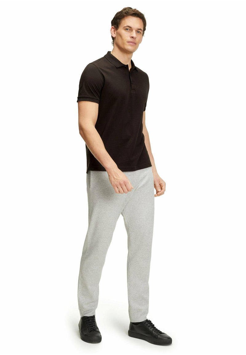 Czarna koszulka polo, krótki rękaw, slim fit; w połączeniu z jasnoszarymi dresami; czarne sneakersy; gładka, bez wzorów czy zdobień.