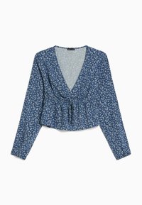 Blå blommig blus med långa ärmar, v-ringning, draperad midja och knytdetalj. Har små vita blommor på en texturerad bakgrund.