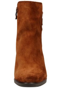 Ruskean mokkanahkaiset nilkkurit, joissa on sileä pinta ja pyöristetty kärki. Niissä on sivuvetoketju ja lyhyt, leveä korko vakauden takaamiseksi.