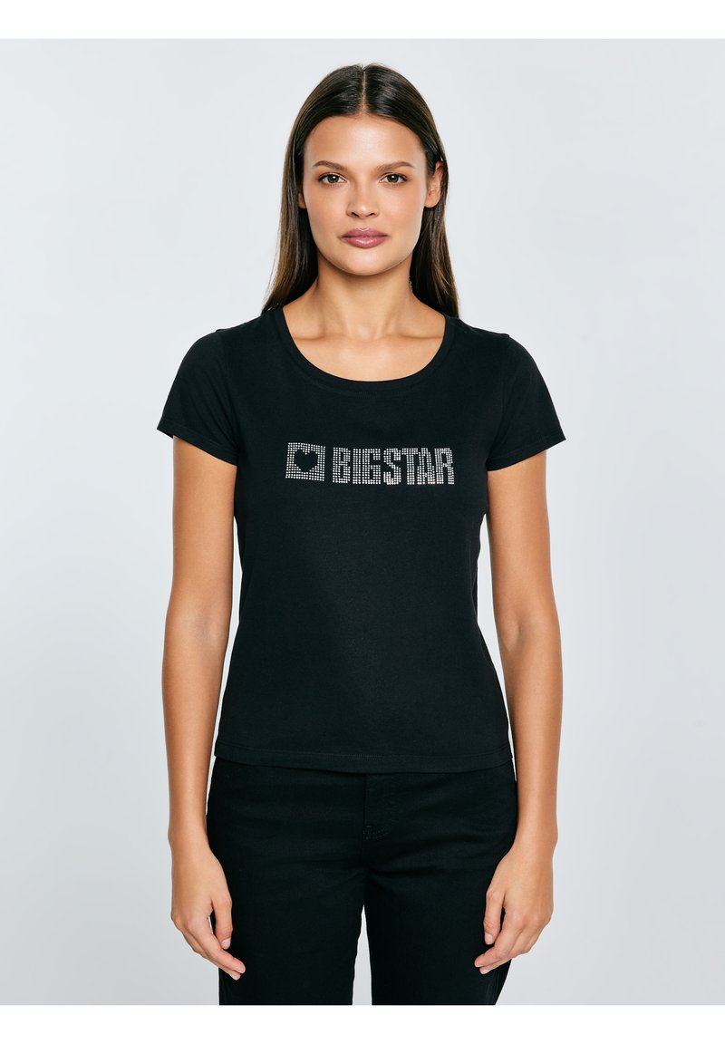 Czarna koszulka z krótkim rękawem z okrągłym dekoltem i grafiką słowa "BIGSTAR" z kryształków z przodu. Miękki bawełniany materiał.
