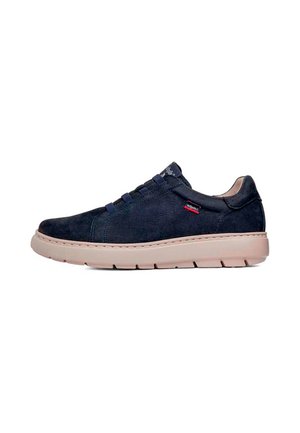 Zapatilla casual de ante azul oscuro con suela gruesa beige y cordones elásticos que muestran una pequeña etiqueta de marca roja y negra en el lateral.