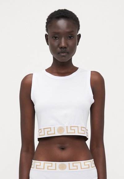 Witte gecropte tanktop van zachte katoen met een gladde textuur. Voorzien van een gouden geometrische band aan de onderrand en een centraal logodetail.