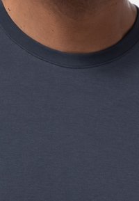 T-shirt a girocollo di un blu navy scuro, realizzato in un tessuto morbido e liscio, con una vestibilità standard e una texture sottile; non sono visibili motivi o dettagli.