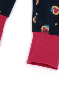 Leggings in tessuto navy con polsini rossi, caratterizzati da un motivo di cuori e stelline dorate. Texture morbida con una finitura liscia.