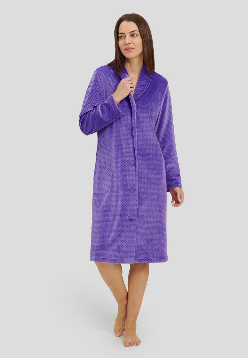 Ropa de abrigo button-up de color púrpura, texturizada, con cuello de chal y dos bolsillos laterales, hecha de material suave, de longitud hasta la rodilla y con mangas largas.