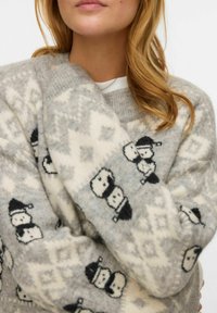 Hall halli kudumismustriga kampsun, millel mustvalged lumememmede mustrid ja geomeetriline kujundus. Pehme tekstuur, lahtine lõige ja laiad varrukad.