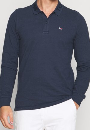 Navy long-sleeve polo shirt made of cotton, with a classic collar, button placket, and logo detail on the chest and collar.