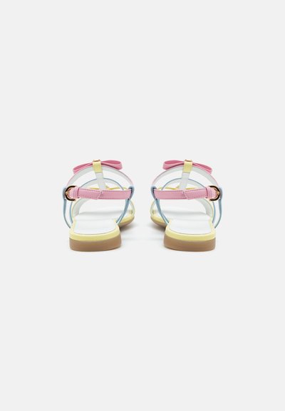 Sandalias multicolores con tiras rosa, azul y amarillas; hebilla ajustable en el tobillo; suela plana; textura suave; diseño minimalista.