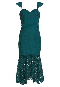 Teal spetsklänning med figurnära bodice, hjärtformad halsringning och spaghettistroppar. Utsvängd nedre kant med blomstercutouts och strukturerad lager.
