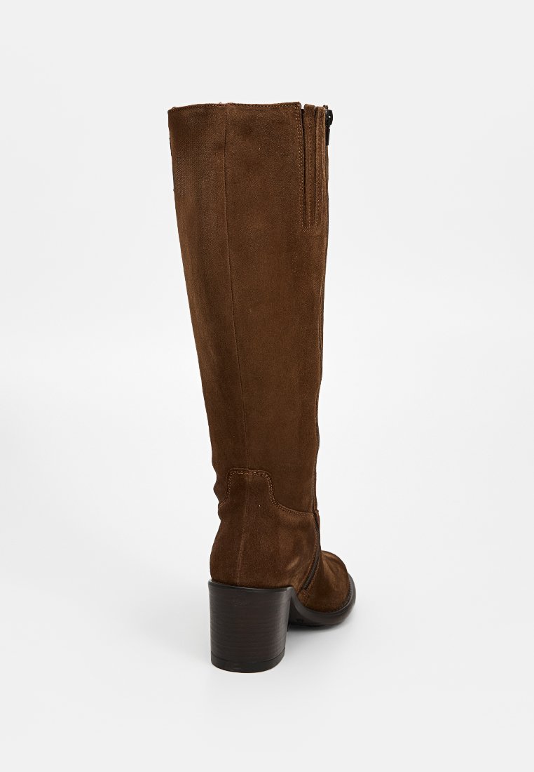 Botas altas de ante marrón con punta redonda, cremallera lateral y tacón ancho. La superficie es suave con una textura blanda.