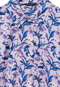 Hellbluse mit floralem Muster in Blau- und Lavendeltönen, spitzem Kragen und goldenen Knöpfen auf der Vorderseite.