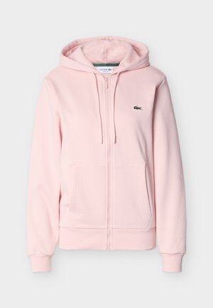 Pink zip-up hoodie made of soft fabric, featuring a kangaroo pocket, drawstrings, and a small logo on the left chest.