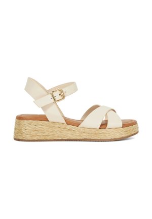 Sandale en faux cuir blanc avec des brides croisées, sangle de cheville avec boucle, et semelle intermédiaire en jute tissé. Semelle intérieure lisse dans une teinte marron clair.