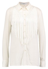 Chemise blanche à boutons avec un panneau en dentelle et une longue frange blanche à l'avant, manches longues et col classique.