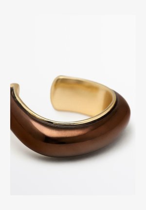 Bruine metalen manchet armband met een glad, afgerond ontwerp en een gouden accentrand, met een gepolijste afwerking en een strak uiterlijk.
