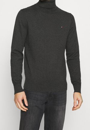 Pull à col roulé gris foncé en tissu doux. Doté de manches longues et de poignets et d'ourlet côtelés. Petit logo sur la poitrine.