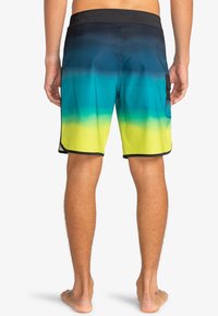 Costumi da bagno da uomo con un design in gradiente che va dal blu navy al verde acqua e giallo brillante, realizzati in un tessuto leggero e ad asciugatura rapida. Comprendono una tasca laterale.