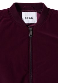 Dark purple jacket with ribbed collar and front zipper, featuring a white label with "CECIL" brand name inside the neckline.