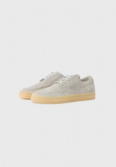 Adidași gri din suede cu un finisaj texturat, vârf rotund, design cu șireturi și talpă din cauciuc de culoare bej deschis.