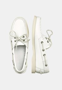 Scarpe da barca in pelle bianca con texture liscia, punta rotonda e design con lacci. Presentano dettagli di cucitura e una suola in gomma chiara.