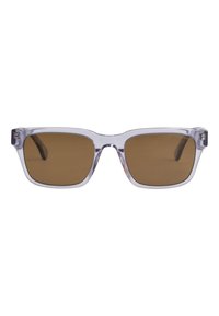 Gafas de sol rectangulares de plástico transparente con lentes polarizados marrones. Presentan montura gruesa y un diseño sencillo, con un pequeño logo en el lateral.