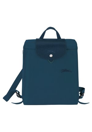 Dunkelblauer quadratischer Rucksack mit strukturierter Klappe und Druckknopfverschluss, zwei verstellbaren Trägern und kleinem geprägtem Logo auf der Vorderseite.