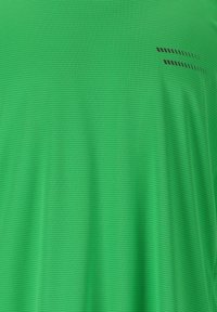 Groene T-shirt met textuur, voorzien van een rasterpatroon en subtiele zwarte accentlijnen aan de bovenlinkerkant. Zachte stof, korte mouwen, ronde hals.