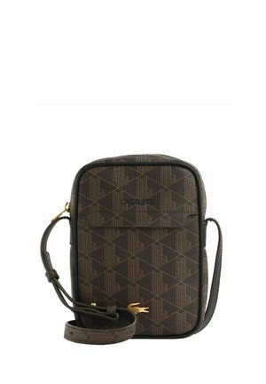 Sac bandoulière marron compact avec motif géométrique, sangle réglable, fermeture éclair et logo crocodile Lacoste doré sur la poche avant.