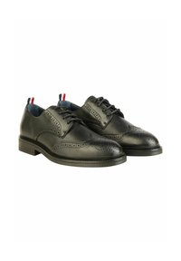 Schwarze Leder-Brogueschuhe mit dekorativen Perforationen, runder Zehenpartie und niedrigem, stabilen Absatz. Merkmale sind blaue Innenausstattung sowie rote und blaue Akzente.