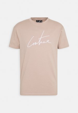 Light beige t-shirt made of cotton, featuring short sleeves, a round neckline, and a contrasting white cursive "Couture" logo.