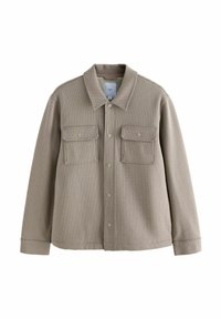 Veste boutonnée beige texturée avec deux poches poitrine à rabat et un col rabattu, présentée sur un fond blanc.