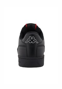 Baskets noires avec une tige en cuir lisse, un col rembourré et des accents rouges. Présente le logo Kappa et une semelle extérieure en caoutchouc texturé.