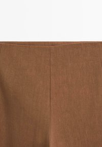 Brązowe lniane spodnie o gładkiej fakturze, z prostymi nogawkami i pionowymi szwami, bez widocznych elementów metalowych ani wzorów.