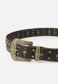 Rjav usnjen pas z zlatim sponko, okrašen z rhinestones in motivi zvezd, z luknjami po celotni dolžini.