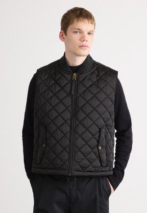 Black quilted vest with a high collar, front zip closure, side pockets, and a textured pattern. Soft fabric with a smooth finish.