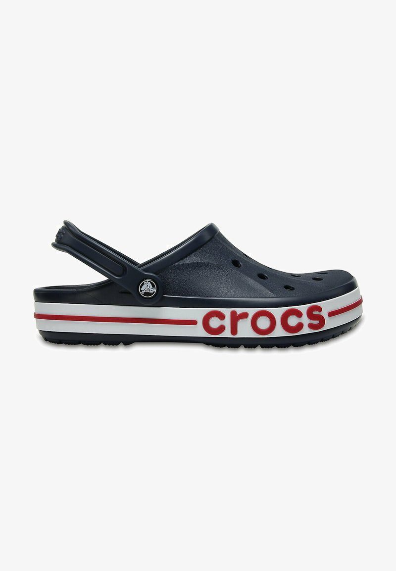 Granatowe klapki Crocs z białą i czerwoną paskowaną podeszwą. Posiadają otwory wentylacyjne oraz tylny pasek z akcentem w postaci logo.