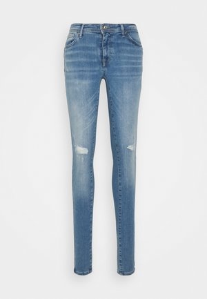Jeans de ganga azul com um corte slim, detalhes desgastados nos joelhos e um design clássico de cinco bolsos. Textura suave e lavagem média.
