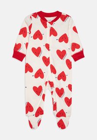 Piros és fehér kezeslábas, mosolygós arcocskákkal díszített szívmintával, hosszú ujjal és elöl cipzárral. Talpas kialakítás, piros mandzsettákkal.