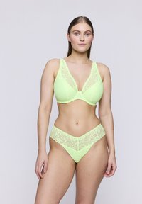 Zielono-limonkowy komplet biustonosza z koronką i stringów, ozdobiony kwiatowymi wzorami, o miękkiej teksturze oraz wycięciu w dekolcie z szerokimi ramiączkami. Gładkie dopasowanie.