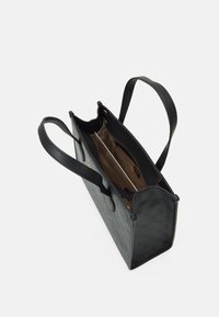 Černá strukturovaná taška přes rameno vyrobená z texturovaného materiálu, s dvěma dlouhými ušima a prostorným interiérem s béžovým podšívkou a zipovou kapsou.